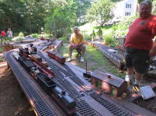 August 17.  Saturday morning and it's time for operations!
The rolling stock is set out in the yards from the storage sheds, and then sweeper trains take the cars to the correct destinations. Paul looks to be supervising, while Jon awaits commands.